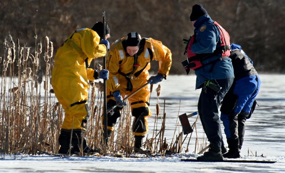 Firefighters break into the ice at Learned Pond in Framingham before removing a body from underneath the ice, Jan. 11, 2021.  