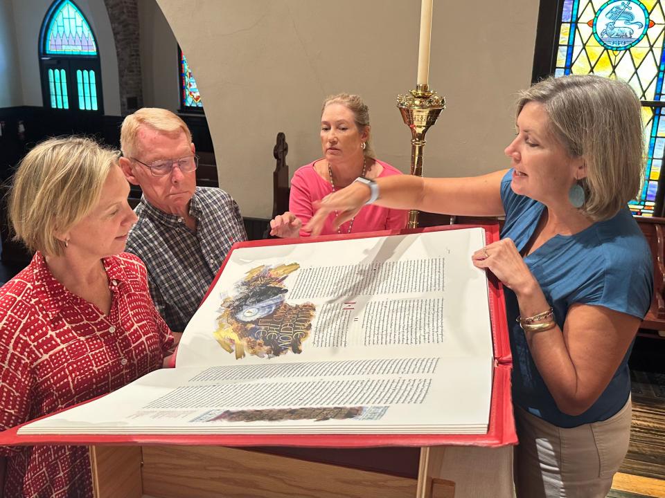 Kate Kile, Director of Finance and Faith Formation at St. John’s Episcopal Church, shares The Saint John’s Bible with a group of parishioners in the church sanctuary. The church will began a marathon Bible reading Aug. 24, 2023.