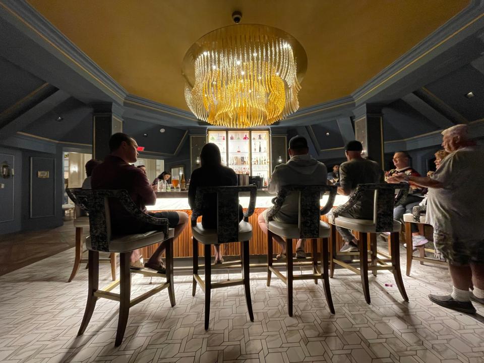 people sitting at the bar at enchanted rose lounge in disney's grand floridian resort