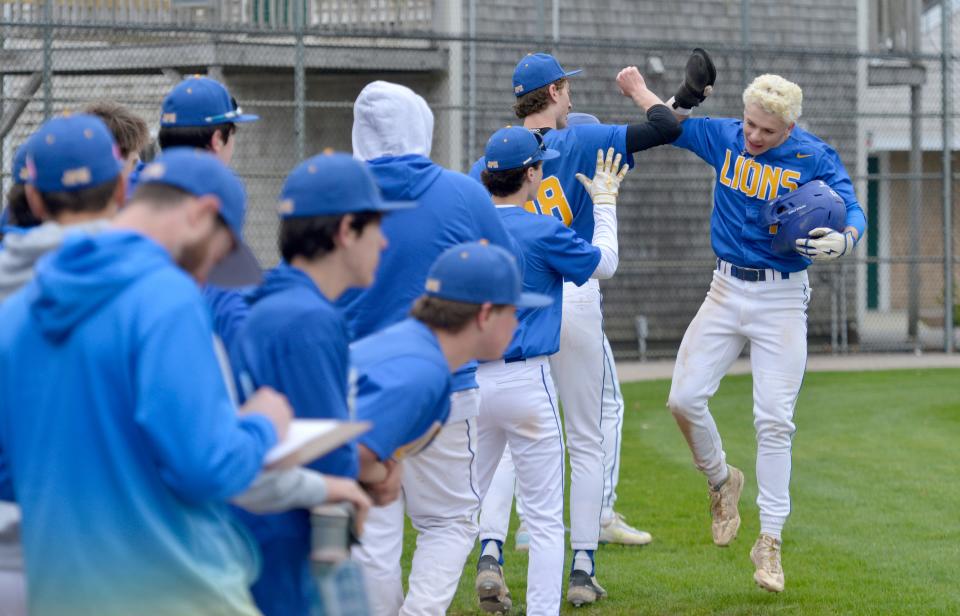 St. John Paul II's Logan Our, right, celebrates with his teammates after scoring in the first inning.