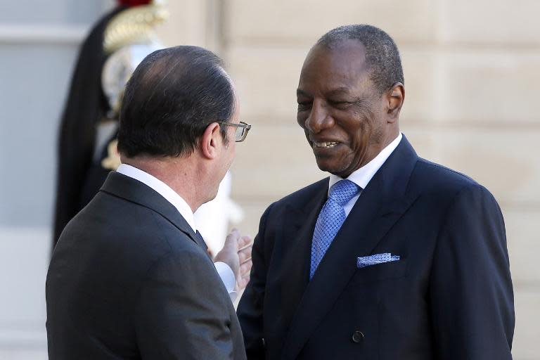 French President Francois Hollande (left) greets his Guinean counterpart Alpha Conde on April 22, 2015 in Paris