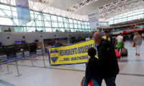 Fanáticos del Boca Juniors muestran una pancarta con los colores del equipo antes de partir a España para asistir a la final de la Copa Libertadores contra River Plate, en el aeropuerto de Ezeiza en Buenos Aires, Argentina, 6 de diciembre de 2018. REUTERS / Marcos Brindicci