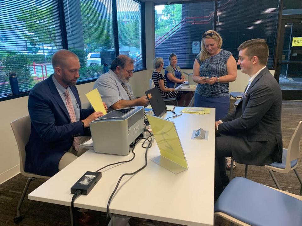 Ben Copeland (right), a UNC Charlotte student running for an at-large seat on the Charlotte City Council, fills out paperwork to get on the ballot Friday at the Mecklenburg County Board of Elections.