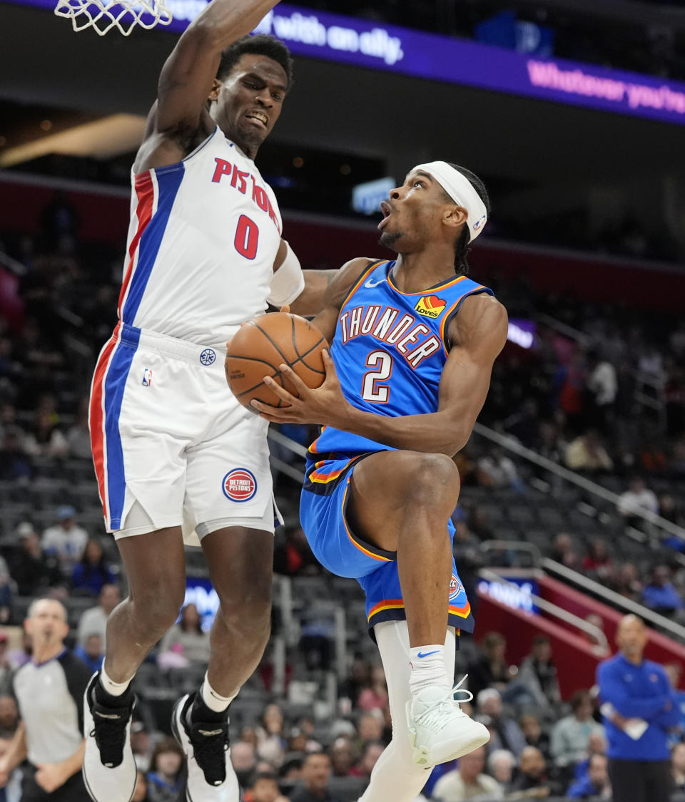 Oklahoma City Thunder guard Shai Gilgeous-Alexander (2) attempts a layup as Detroit Pistons center Jalen Duren (0) defends during the second half of an NBA basketball game, Sunday, Jan. 28, 2024, in Detroit. (AP Photo/Carlos Osorio)