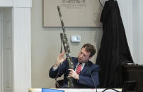 Firearms examiner Paul Greer removes a shotgun from an evidence box during Alex Murdaugh's double murder trial at the Colleton County Courthouse in Walterboro, S.C., Friday, Feb. 3, 2023. The 54-year-old attorney is standing trial on two counts of murder in the shootings of his wife and son at their Colleton County home and hunting lodge on June 7, 2021. (Sam Wolfe/The State via AP, Pool)