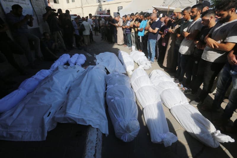 Relatives of Palestinians killed in Israeli attacks mourn as they receive the dead bodies from the morgue of Al-Aqsa Hospital for burial in Deir El-Balah. Omar Ashtawy/APA Images via ZUMA Press Wire/dpa