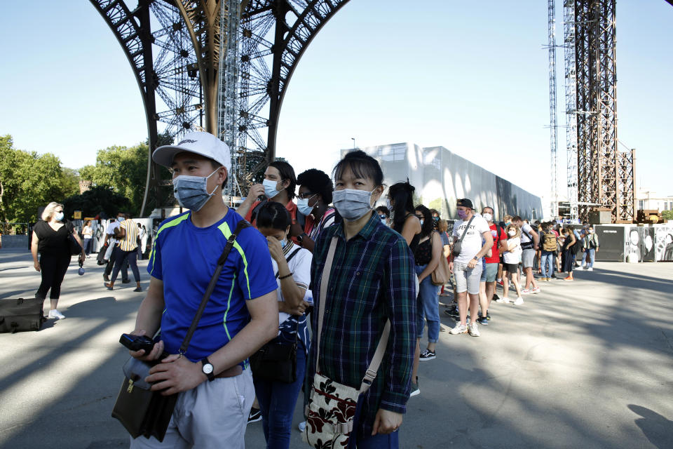 People queue up prior to visit the Eiffel Tower, in Paris, Thursday, June 25, 2020. The Eiffel Tower reopens after the coronavirus pandemic led to the iconic Paris landmark's longest closure since World War II. (AP Photo/Thibault Camus)