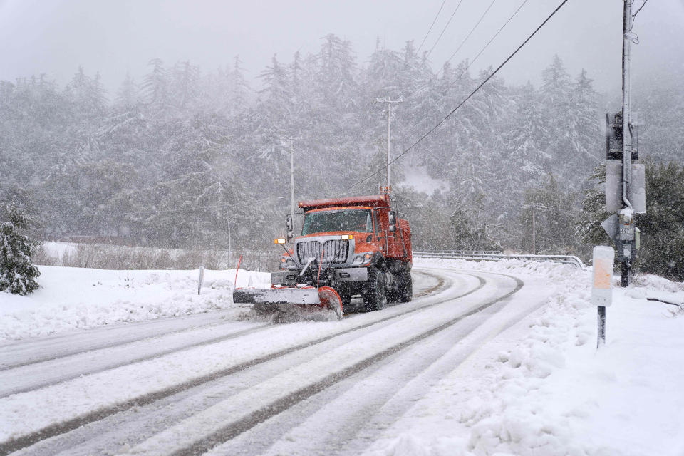 A plow clears snow on Mount Baldy Road in the town of Mount Baldy, California, on February 24, 2023. - Californians more used to flip flops and shorts were wrapping up warm Thursday as a rare winter blizzard, the first in more than 30 years, loomed over Los Angeles, even as the US East Coast basked in summer-like temperatures. (Allison Dinner / AFP - Getty Images)