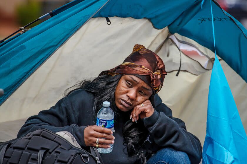 Tierra Signer, who lived in a tent for last 4 months waits, with her belongings, to get housing under Inside Safe program