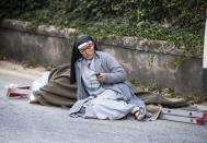 <p>A nun checks her mobile phone as she lies near a victim laid on a ladder following an earthquake in Amatrice Italy, Wednesday, Aug. 24, 2016. (Massimo Percossi/ANSA via AP) </p>