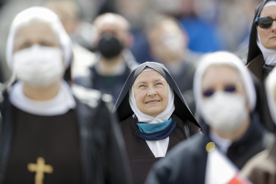 Unas monjas observan al papa Francisco dar la bendición desde su balcón, en la Plaza de San Pedro, en el Vaticano, el 18 de abril de 2021. (AP Foto/Andrew Medichini)