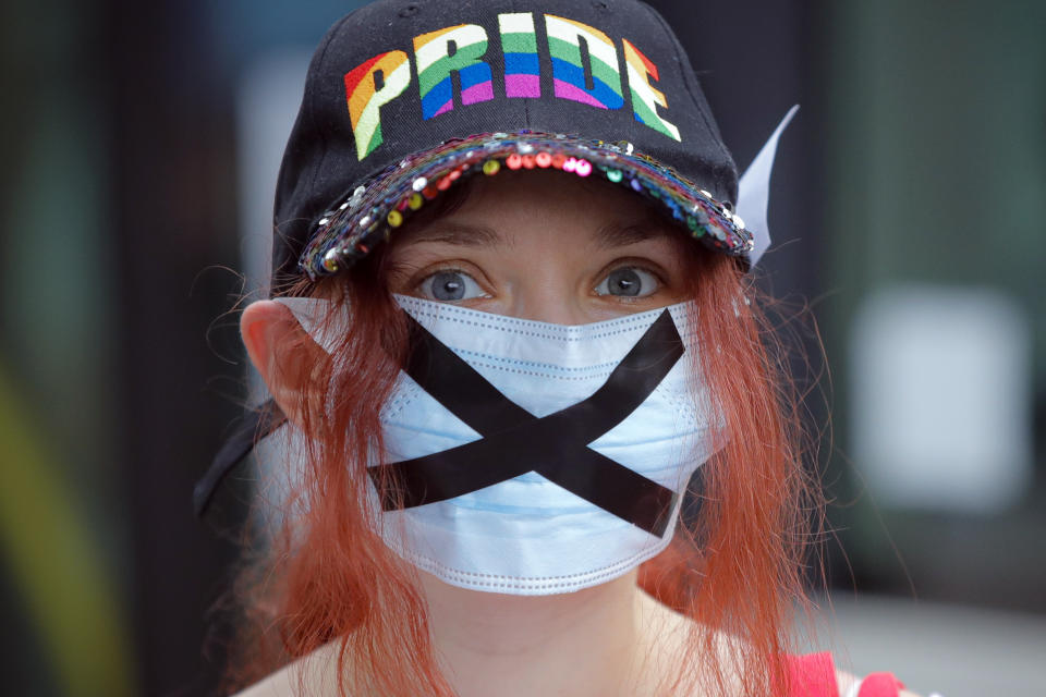 A protester wears a face mask outside the presidential palace in Bucharest, Romania, Thursday, June 18, 2020, during a rally against a law banning the teaching of gender studies. Dozens of protesters gathered outside Bucharest's Cotroceni Presidential Palace, to express their opposition to a law banning the teaching of gender studies in the country's schools and universities and call on President Klaus Iohannis to reject signing the bill and send it back to parliament. (AP Photo/Vadim Ghirda)