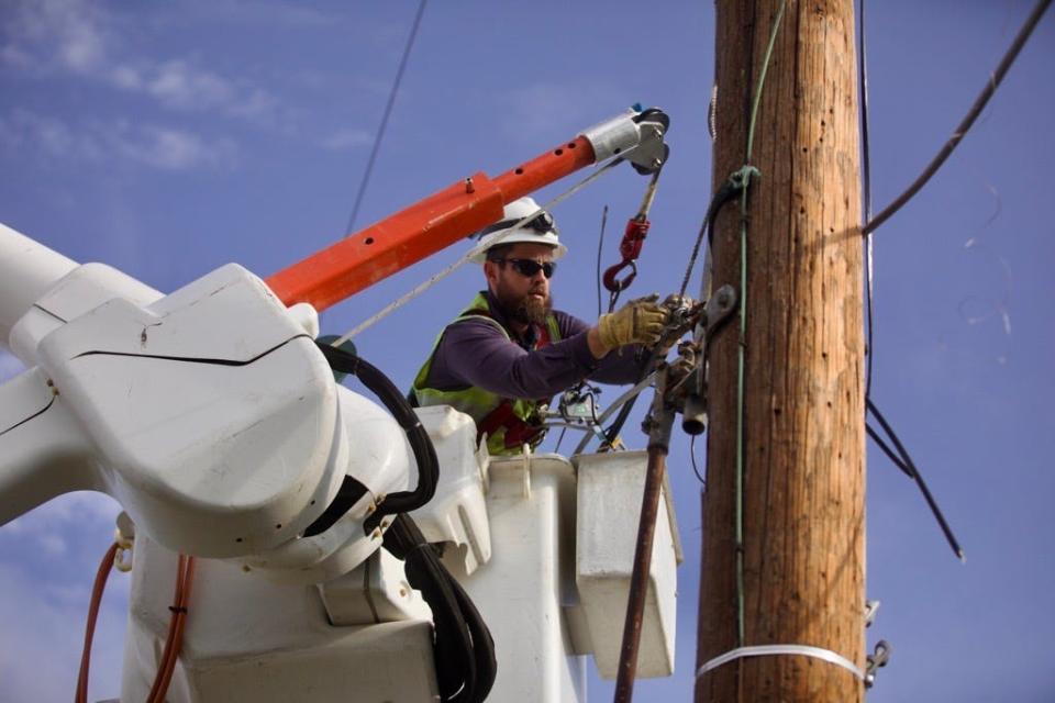 Duke Energy worker cuts phone lines on Goshen Road, on Thursday, July 7, 2022, following the tornado that hit the area the previous day.