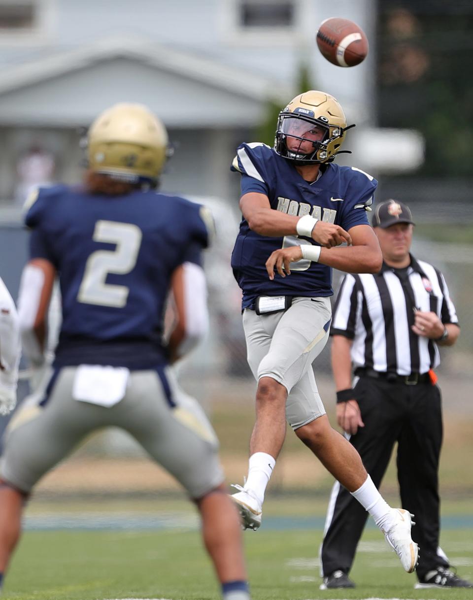Hoban quarterback JacQai Long throws a pass to wide receiver Jayvian Crable during the first half of a high school football game against Iona Prep, Saturday, Sept. 3, 2022, in Akron, Ohio.