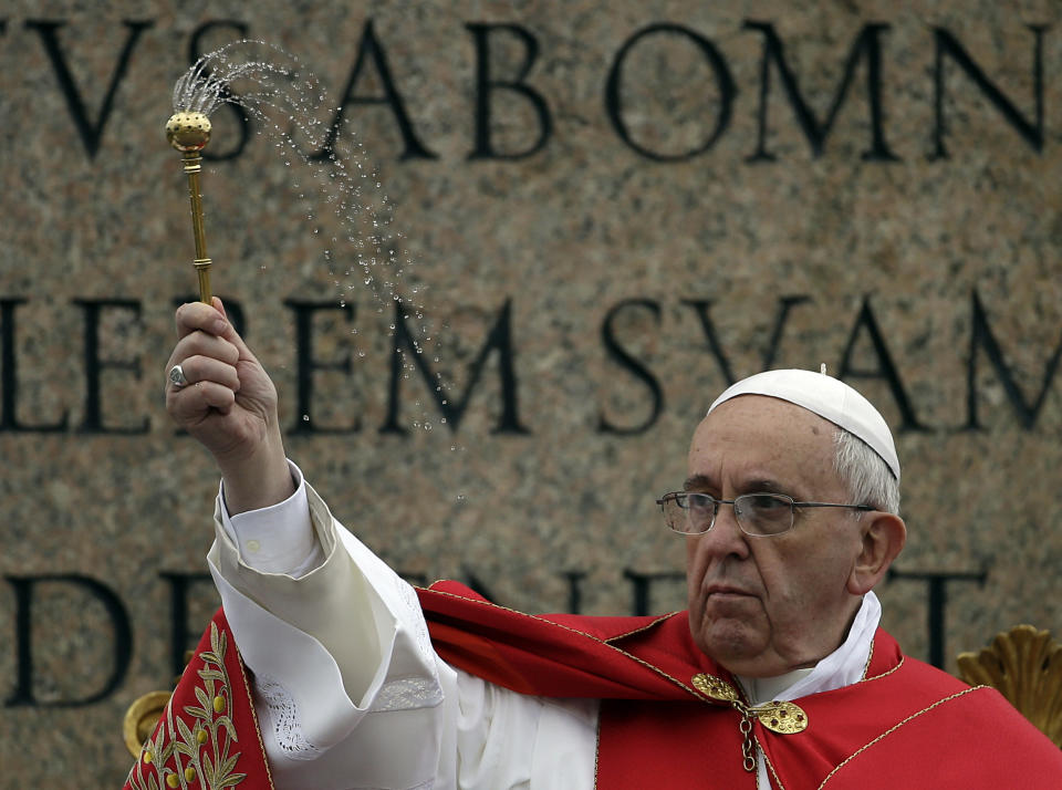 Pope Francis asperges holy water as he celebrates a Palm Sunday mass in St. Peter's Square, at the Vatican, Sunday, April 13, 2014. (AP Photo/Gregorio Borgia)