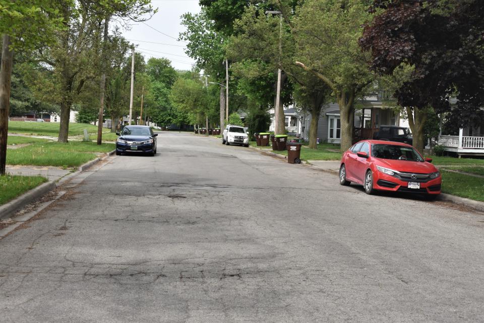 Cars are parked Tuesday along the sides of Cross Street in Adrian. Cross Street is a one-way street connecting South Main and South Winter streets. The city of Adrian is looking into the possibility of converting Cross Street into a two-way street.