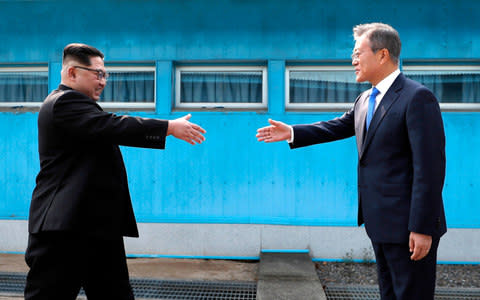 North Korean leader Kim Jong Un and South Korean President Moon Jae-in walk across the military demarcation line - Credit: Koreas Summit