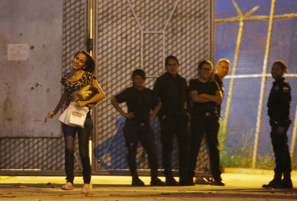 Karen Palacios, left, runs to her family after being released from prison in Los Teques on the outskirts of Caracas, Venezuela, Tuesday, July 16, 2019. Palacios who plays the clarinet and was cut from the National Philharmonic for criticizing the government, and who was detained for 6 weeks, was released today. (AP Photo/Ariana Cubillos)