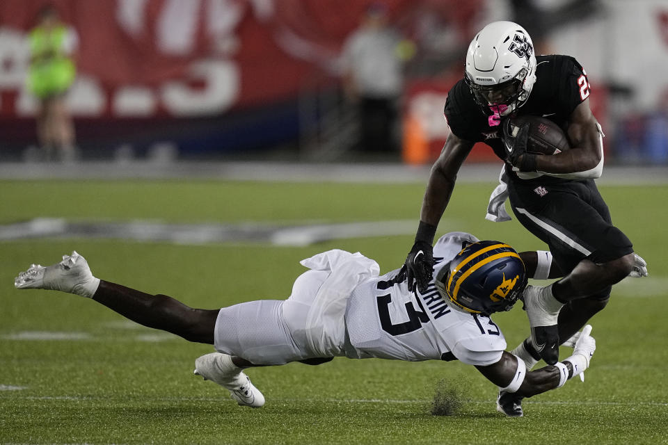 West Virginia safety Hershey McLaurin (13) stops Houston running back Parker Jenkins (23) during the second quarter of an NCAA college football game Thursday, Oct. 12, 2023, in Houston. (AP Photo/Kevin M. Cox)