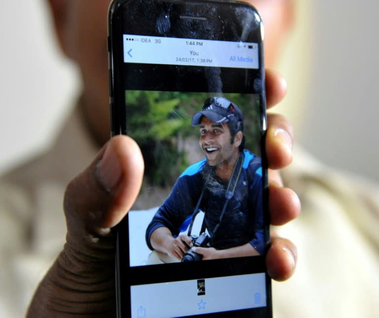 Jagan Mohan Reddy holds a smartphone with an image of his son Alok Madasani at his residence in Hyderabad on February 24, 2017, after Alok was injured in the shooting of two Indian men in the US state of Kansas