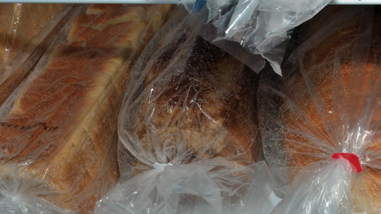 Four bread loaves in a freezer.