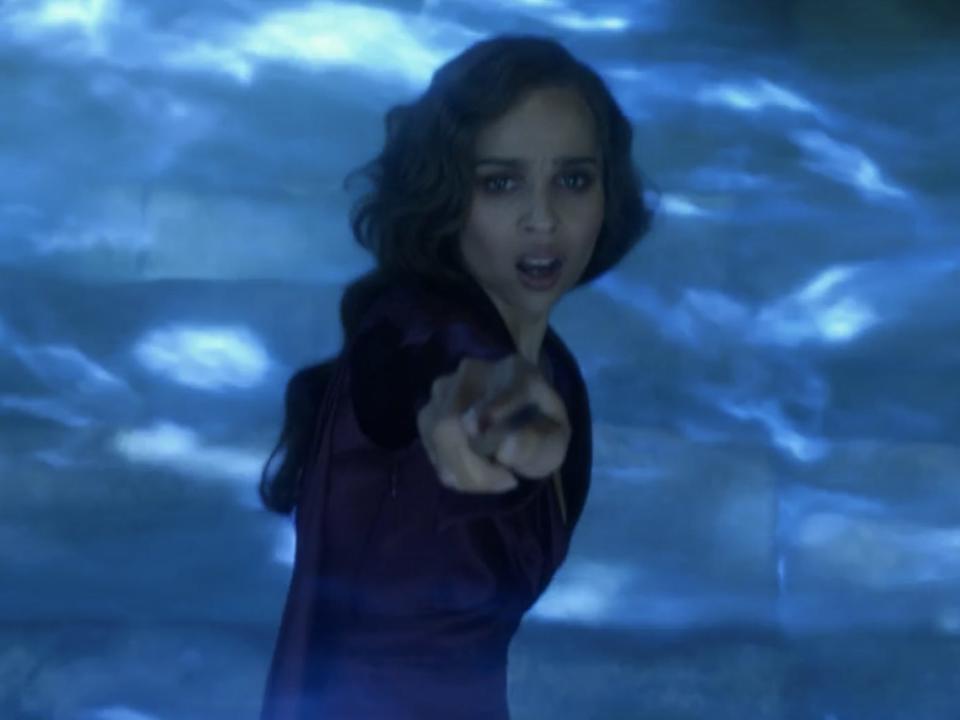 leta lestrange pointing her want towards the camera, with blue fire swirling around her