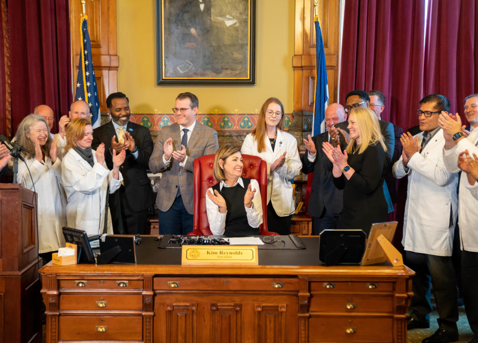 Governor Kim Reynolds celebrates after signing a bill that will create a cap on noneconomic damages in medical malpractice cases, Thursday, Feb. 16, 2023.