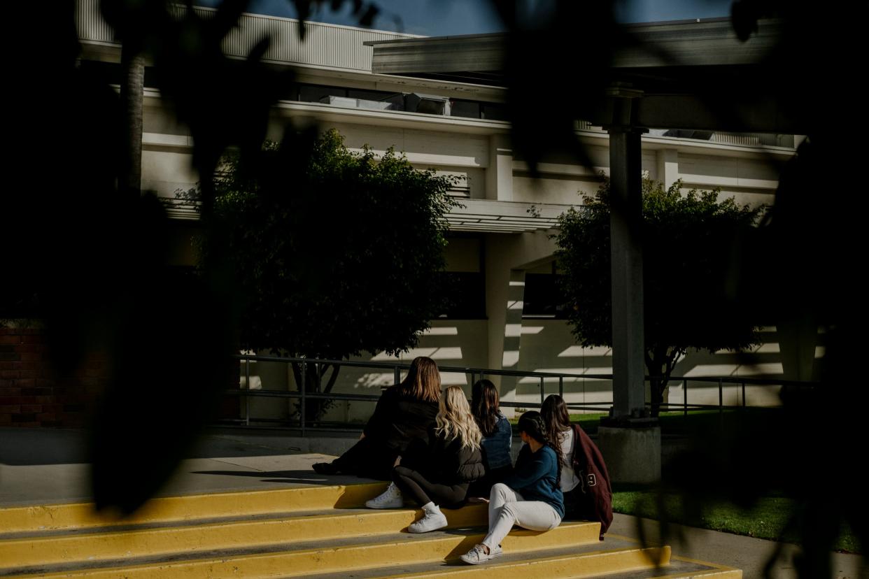 A photo of a group of women standing in front of Rosemead High School facing away from the camera