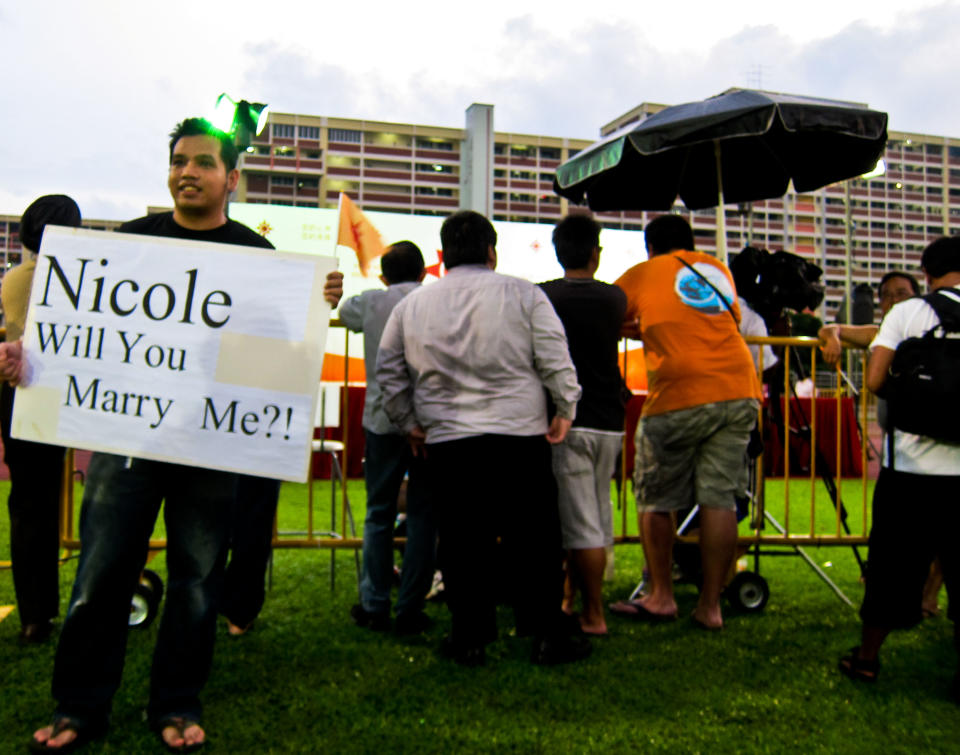 An NSP supporter comes in early to the rally with his sign. (Yahoo! photo/ Liyana Low)