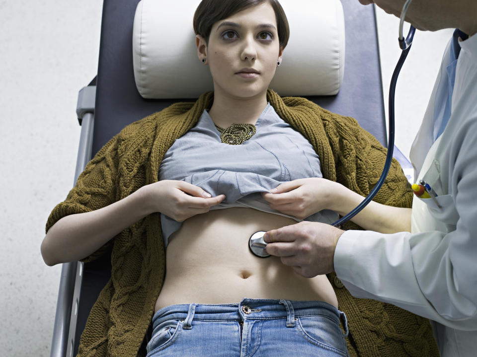 Doctor listening to patient's heart with stethoscope during medical examination