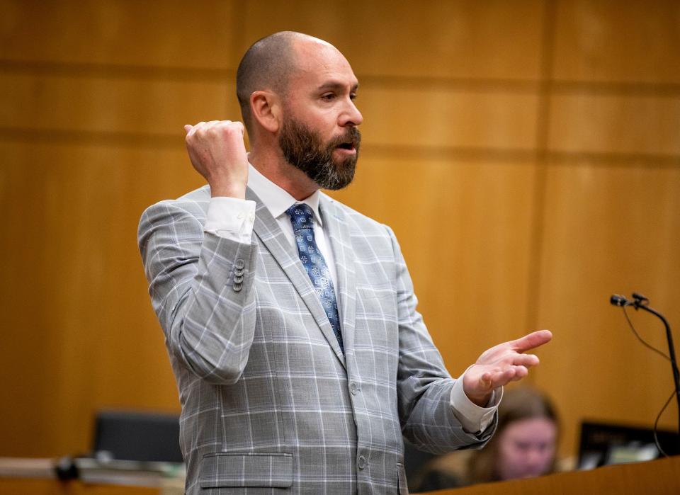 Assistant State Attorney Mark Levine makes a stabbing motion with his hand as he explains how the Hendersons died Nov. 10, 2020, in their Lake Morton home..