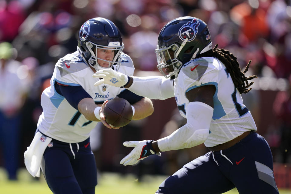 Tennessee Titans quarterback Ryan Tannehill, left, hands the ball off to running back Derrick Henry in the first half of an NFL football game against the Washington Commanders, Sunday, Oct. 9, 2022, in Landover, Md. (AP Photo/Alex Brandon)