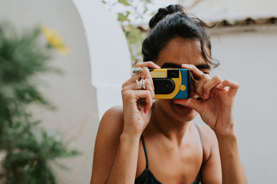 A person taking a photo with a disposable camera