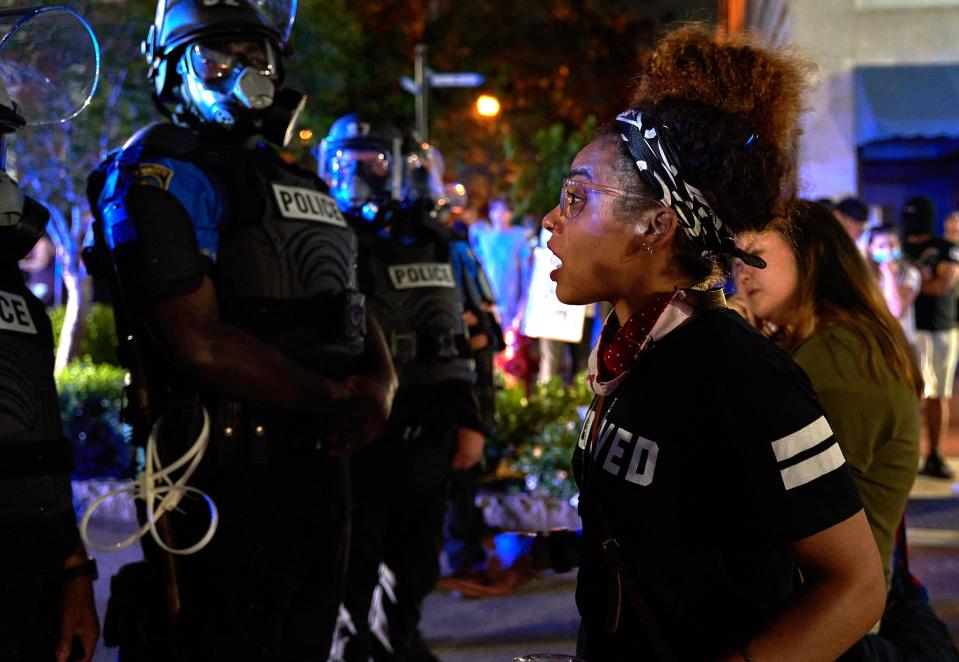 Lily Nicole talks with officers with the Wilmington Police Department during a confrontation between protesters and police in downtown Wilmington, N.C., Sunday, May 31, 2020. The protest turned confrontational as protesters and police clashed a day after a peaceful protest was held to show solidarity with George Floyd.