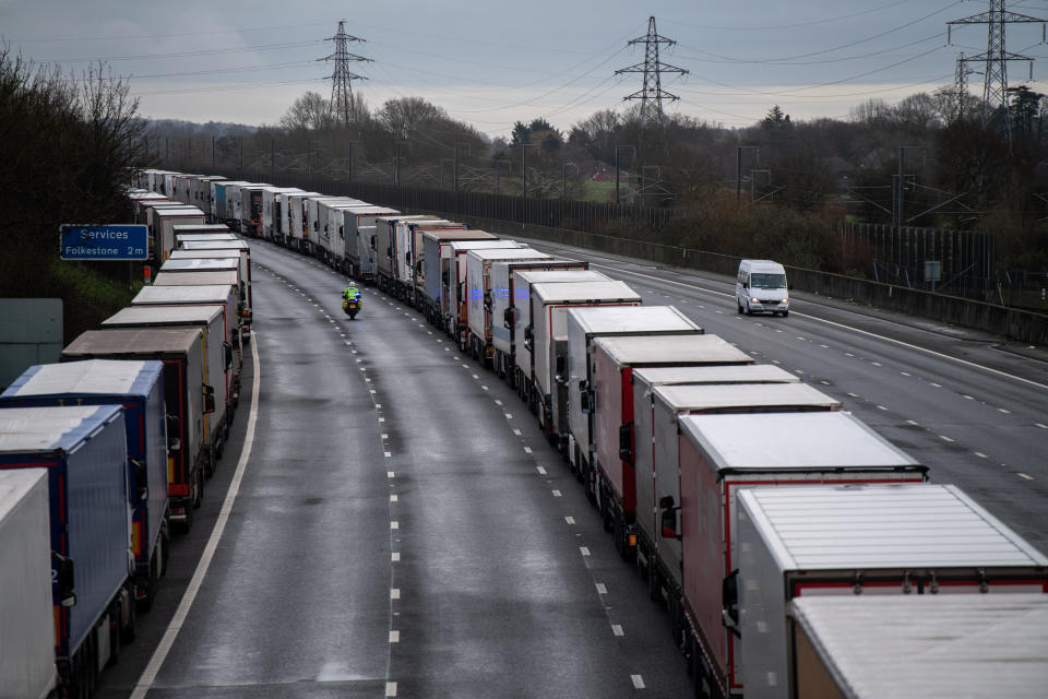 SELLINDGE, ENGLAND - DECEMBER 22: Lorries are stacked along the M20 motorway as the border to France is closed on December 22, 2020 in Sellindge, United Kingdom. Nearly 1000 lorries remained stacked up in Kent as drivers waited for a resumption of travel from the port of Dover to France. On Sunday, France abruptly halted freight and passenger travel from the UK over concerns about the UK's surging covid-19 cases and a new variant of the virus. (Photo by Chris J Ratcliffe/Getty Images)