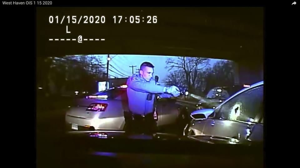 This Jan. 15, 2020, still image from dashboard camera video released by the Connecticut State Police shows Trooper Brian North, left, after he discharged his weapon beside vehicle stopped in West Haven, Conn. North fatally shot Mubarak Soulemane following a high-speed chase along Interstate 95 after Soulemane,19, had carjacked the vehicle in Norwalk, Conn. Clergy and relatives of Soulemane have called for the trooper be sent home on suspension and are asking for more de-escalation training. (Connecticut State Police via AP)