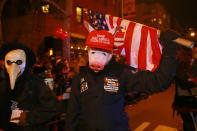 <p>A man wearing a pig mask and an anti-Trump hat carries a U.S. flag in the 44th annual Village Halloween Parade in New York City on Oct. 31, 2017. (Photo: Gordon Donovan/Yahoo News) </p>