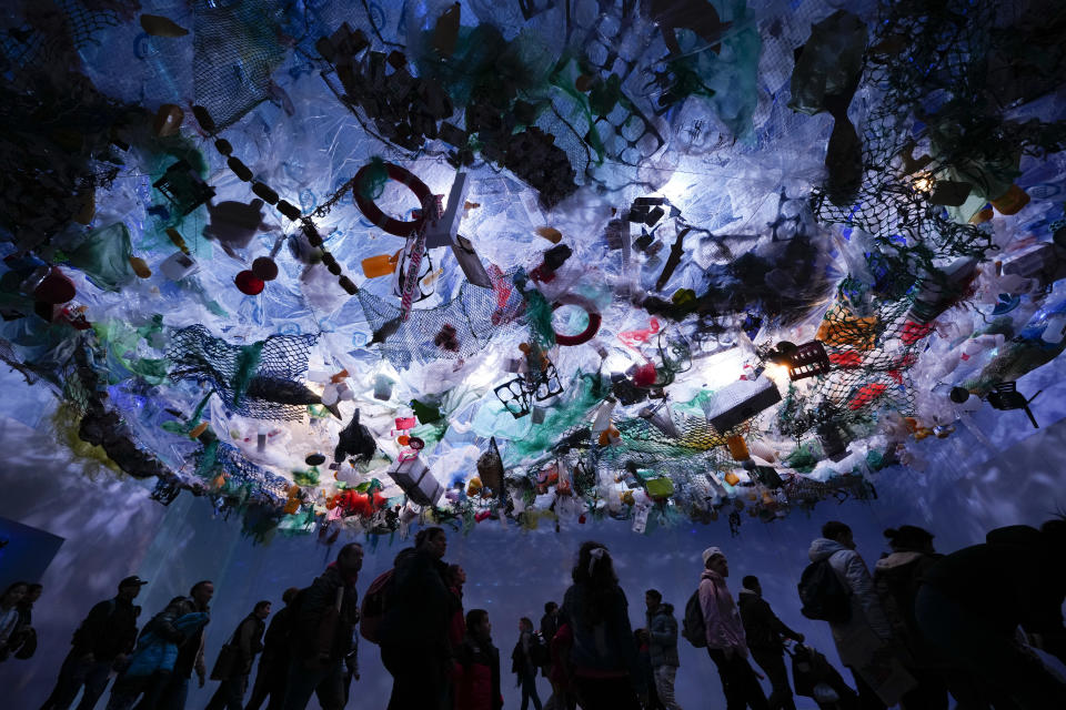 Un grupo camina por una exposición que simula la contaminación de los mares durante la 11ma edición de la muestra Tecnópolis de ciencia, tecnología, industria y arte, el 17 de julio de 2022, en Buenos Aires, Argentina. (AP Foto/Natacha Pisarenko)