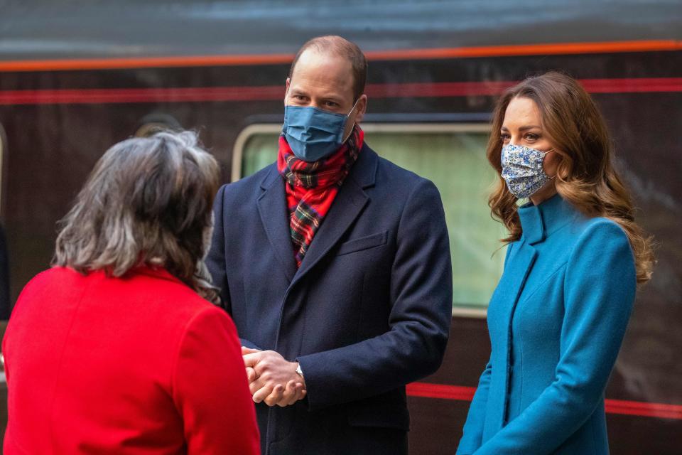 Britain's Prince William, Duke of Cambridge (C) and Britain's Catherine, Duchess of Cambridge (R) speak with Deputy Lord Lieutenant Sandra Cumming (L) after disembarking the Royal train as they arrive at Edinburgh Waverley station for a visit to the Scottish Ambulance Service in Newbridge, Edinburgh in Scotland  on December 7, 2020, on their first full day of engagements on their tour of the UK. - During their trip, their Royal Highnesses hope to pay tribute to individuals, organisations and initiatives across the country that have gone above and beyond to support their local communities this year. (Photo by Andy BARR / POOL / AFP) (Photo by ANDY BARR/POOL/AFP via Getty Images)