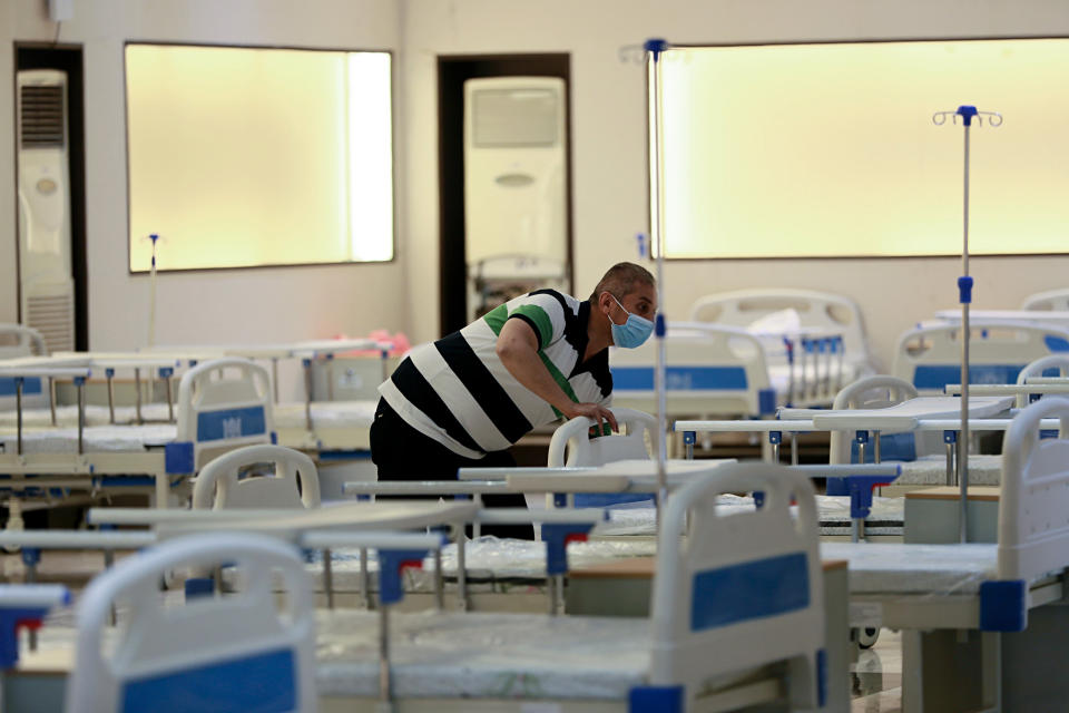 In this Saturday, June 20, 2020 photo, workers set up a field hospital to treat patients with COVID-19 in Baghdad, Iraq. New field hospitals have been erected to treat virus patients as hospitals reach capacity, but health workers fear the worst is still to come. (AP Photo/Hadi Mizban)