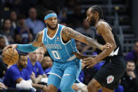 Charlotte Hornets forward Miles Bridges (0) runs the offense against Los Angeles Clippers forward Kawhi Leonard during the first half of an NBA basketball game in Charlotte, N.C., Sunday, March 31, 2024. (AP Photo/Nell Redmond)