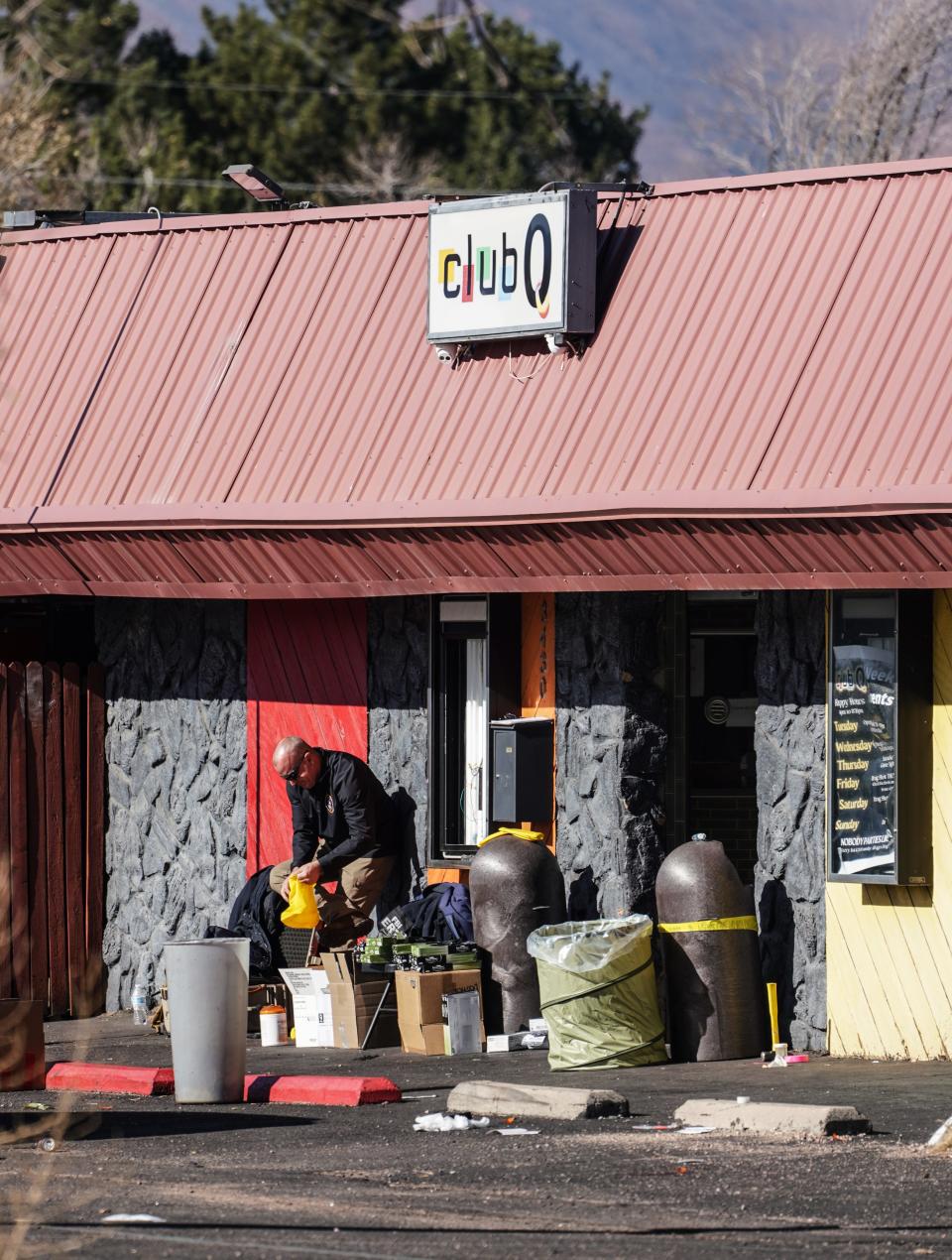 A police investigator puts on protective booties before entering the crime scene at Club Q in Colorado Springs on Tuesday, Nov. 22, 2022.