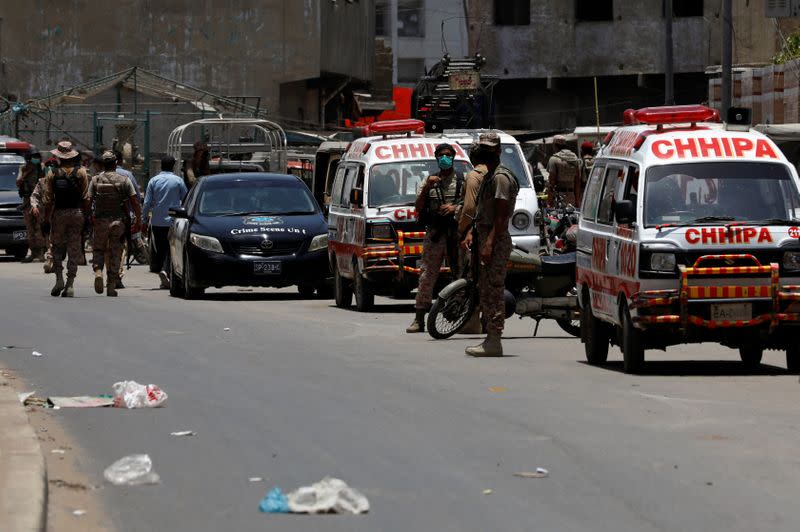 Paramilitary soldiers and ambulances are seen, after a grenade blast outside a college, in Karachi