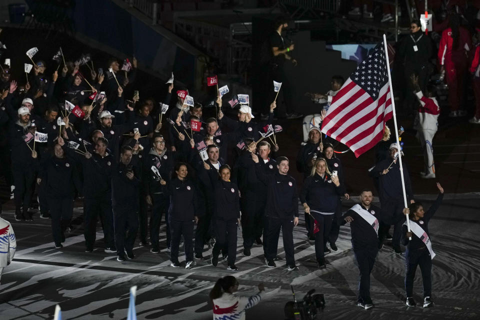 Jordan Chiles and Vincent Hancock of the United States carry their country's flag during the opening ceremony of the Pan American Games at the National Stadium in Santiago, Chile, Friday, Oct. 20, 2023. (AP Photo/Esteban Felix)