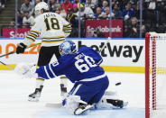 The puck sails wide of the net as Boston Bruins' Pavel Zacha (18) screens Toronto Maple Leafs goaltender Joseph Woll (60) during first-period action in Game 6 of an NHL hockey Stanley Cup first-round playoff series in Toronto, Thursday, May 2, 2024. (Nathan Denette/The Canadian Press via AP)