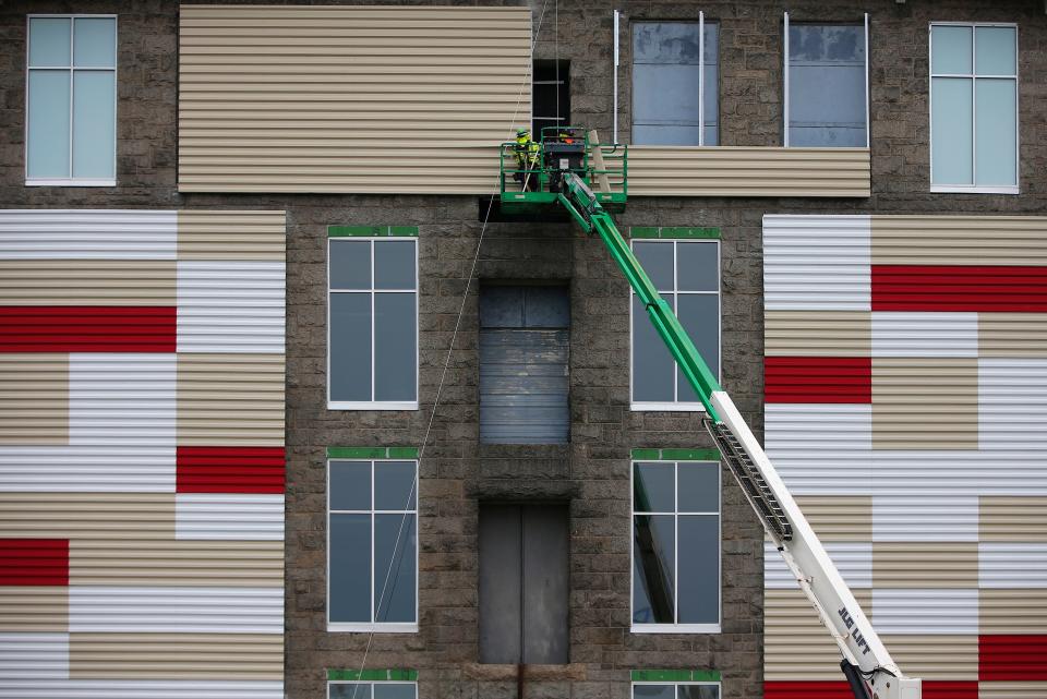 Workers install new siding on an old mill on Plymouth Avenue in Fall River.