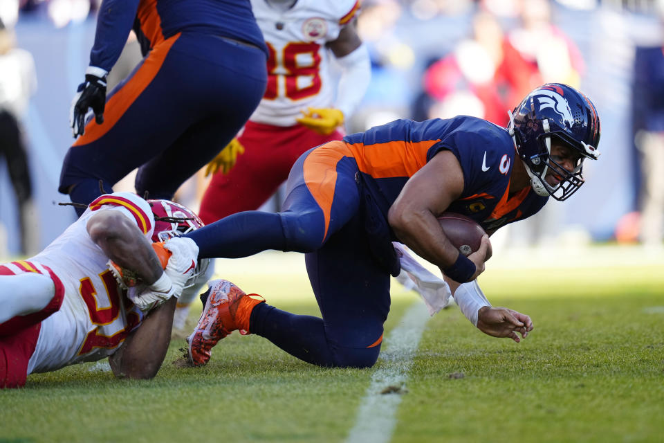 Denver Broncos quarterback Russell Wilson, right, is sacked by Kansas City Chiefs defensive end Mike Danna (51) during the first half of an NFL football game Sunday, Dec. 11, 2022, in Denver. (AP Photo/Jack Dempsey)