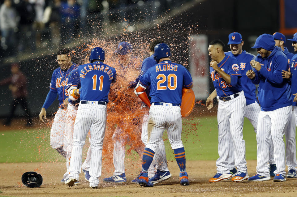 New York Mets Adeiny Hechavarria (11) and Mets Pete Alonso (20) douse New York Mets Amed Rosario with Gatorade after Rosario hit a walk-off, RBI single to lift the Mets to a 6-5 victory over the Washington Nationals in a baseball game, Tuesday, May 21, 2019, in New York. (AP Photo/Kathy Willens)