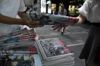 People buy a copy of Apple Daily at a news stand at a downtown street in Hong Kong Tuesday, Aug. 11, 2020, a day after the arrest of its founder Jimmy Lai. Hong Kong authorities arrested media tycoon Jimmy Lai on Monday, broadening their enforcement of a new national security law and stoking fears of a crackdown on the semi-autonomous region's free press.(AP Photo/Vincent Yu)