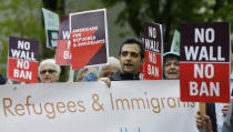 FILE - In this May 15, 2017, file photo, protesters hold signs during a demonstration against President Donald Trump's revised travel ban, outside a federal courthouse in Seattle. Refugee advocates, including faith-based groups that President Donald Trump is courting in his re-election bid, called on Congress Thursday, Oct. 1, 2020, to halt his administration’s plans to slash the limit on refugees allowed into the U.S. to a record low, saying it goes against America’s values. (AP Photo/Ted S. Warren, File)